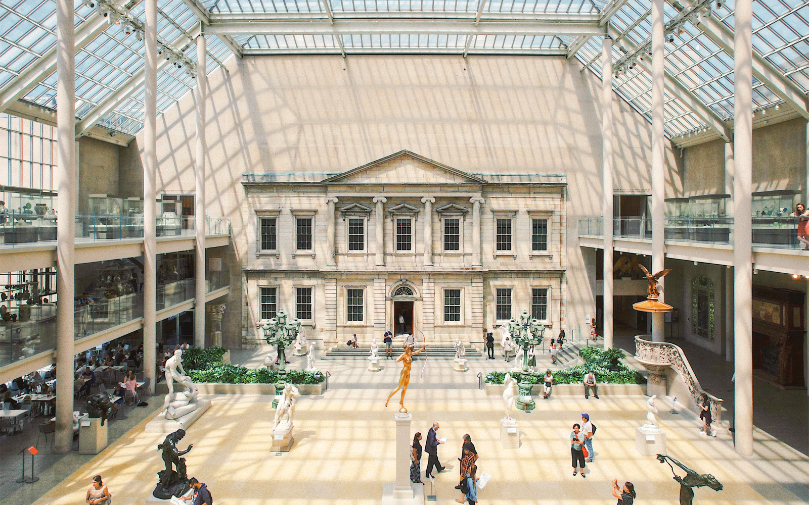 Metropolitan Museum of Art interior, New York, showcasing classical sculptures and visitors exploring exhibits.