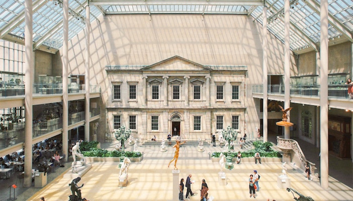 Metropolitan Museum of Art interior, New York, showcasing classical sculptures and visitors exploring exhibits.