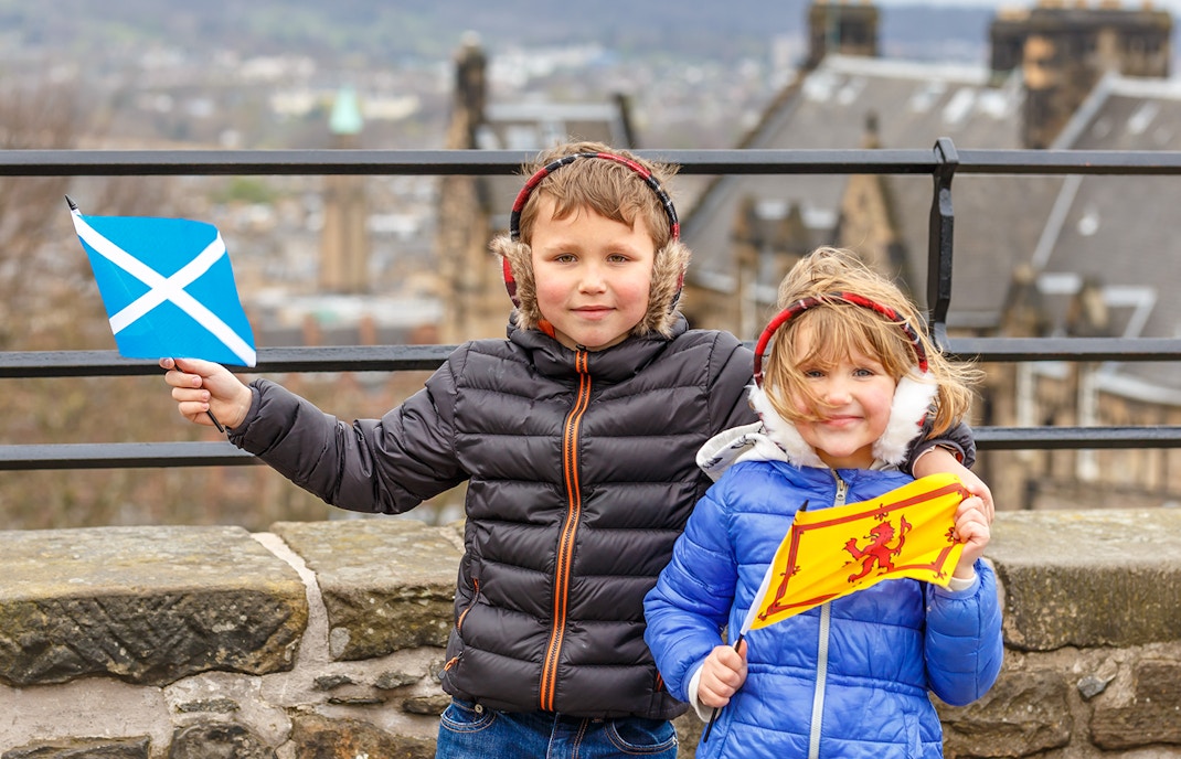 Children holding Scottish flags at Edinburgh Castle.