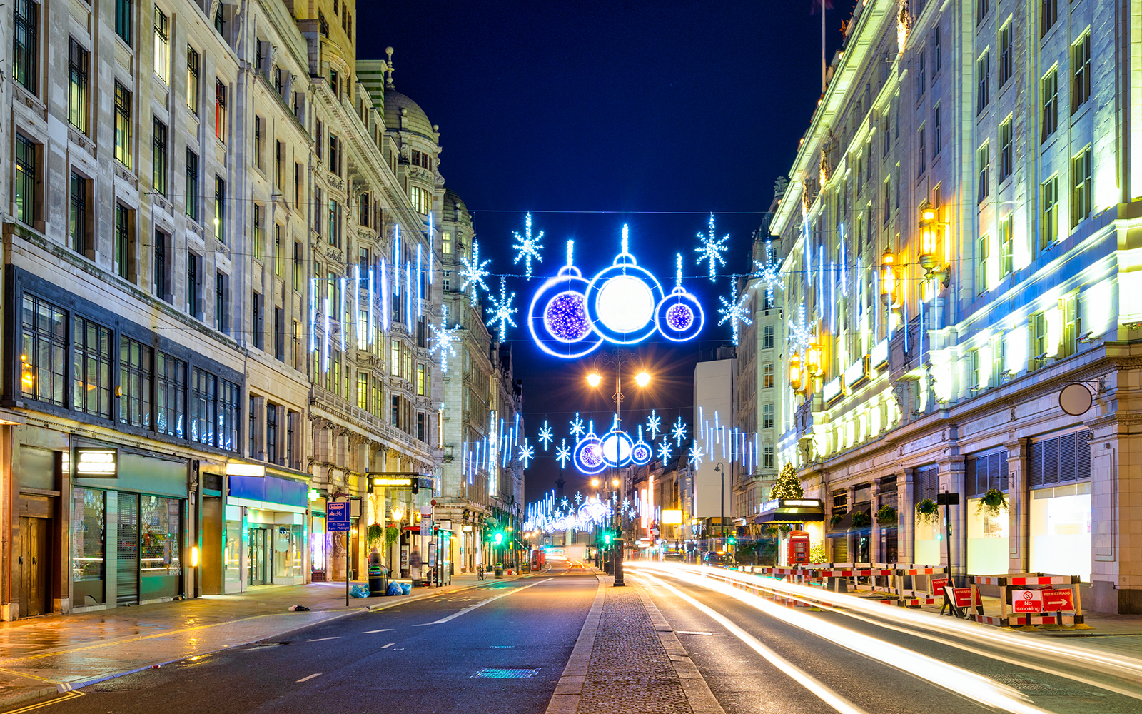 London street with Christmas lights and decorations during Big Bus night tour.