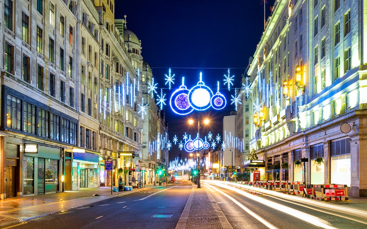 London street with Christmas lights and decorations during Big Bus night tour.