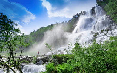 Waterfall in lush green landscape near Bergen, part of the Nærøyfjord cruise and Flåm Railway tour.