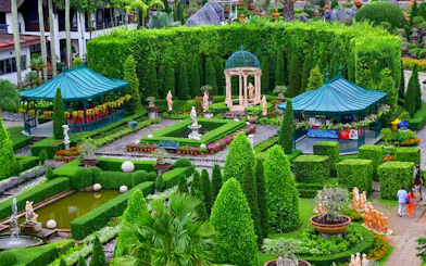 Nong Nooch Tropical Garden with manicured hedges, statues, and gazebos in Pattaya, Thailand.
