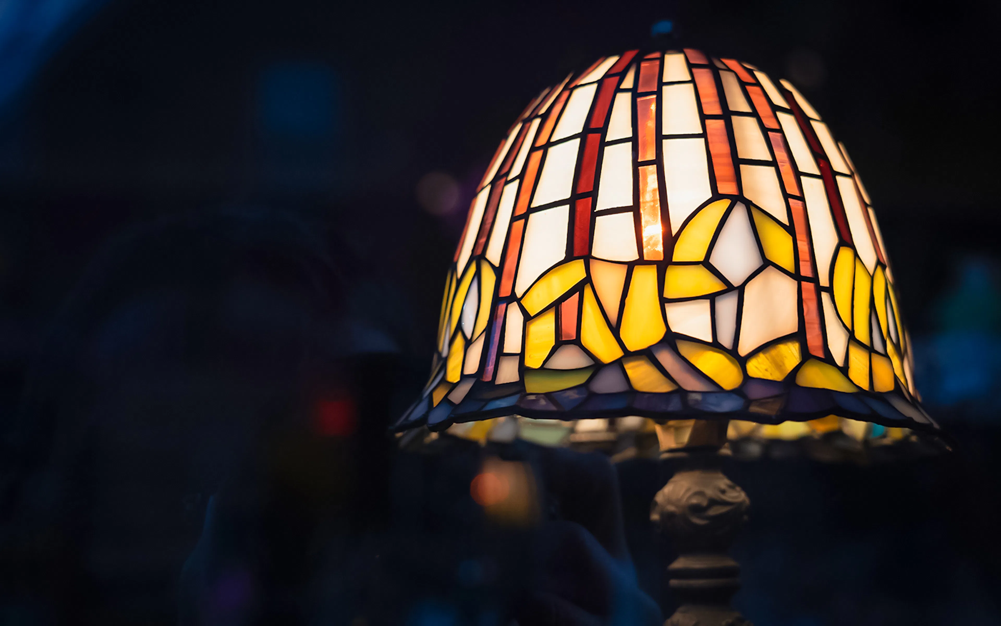 Stained glass Tiffany lamp with floral design in warm colors.