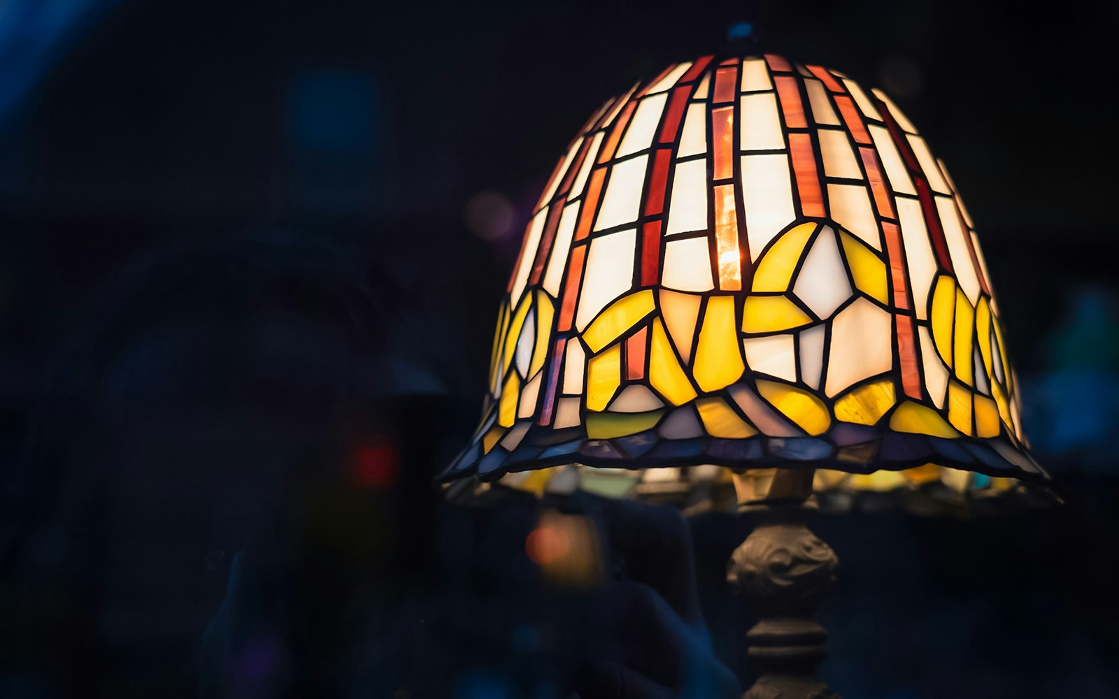 Stained glass Tiffany lamp with floral design in warm colors.