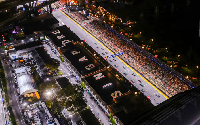 Aerial view of illuminated Formula 1 track at night during Singapore Grand Prix.