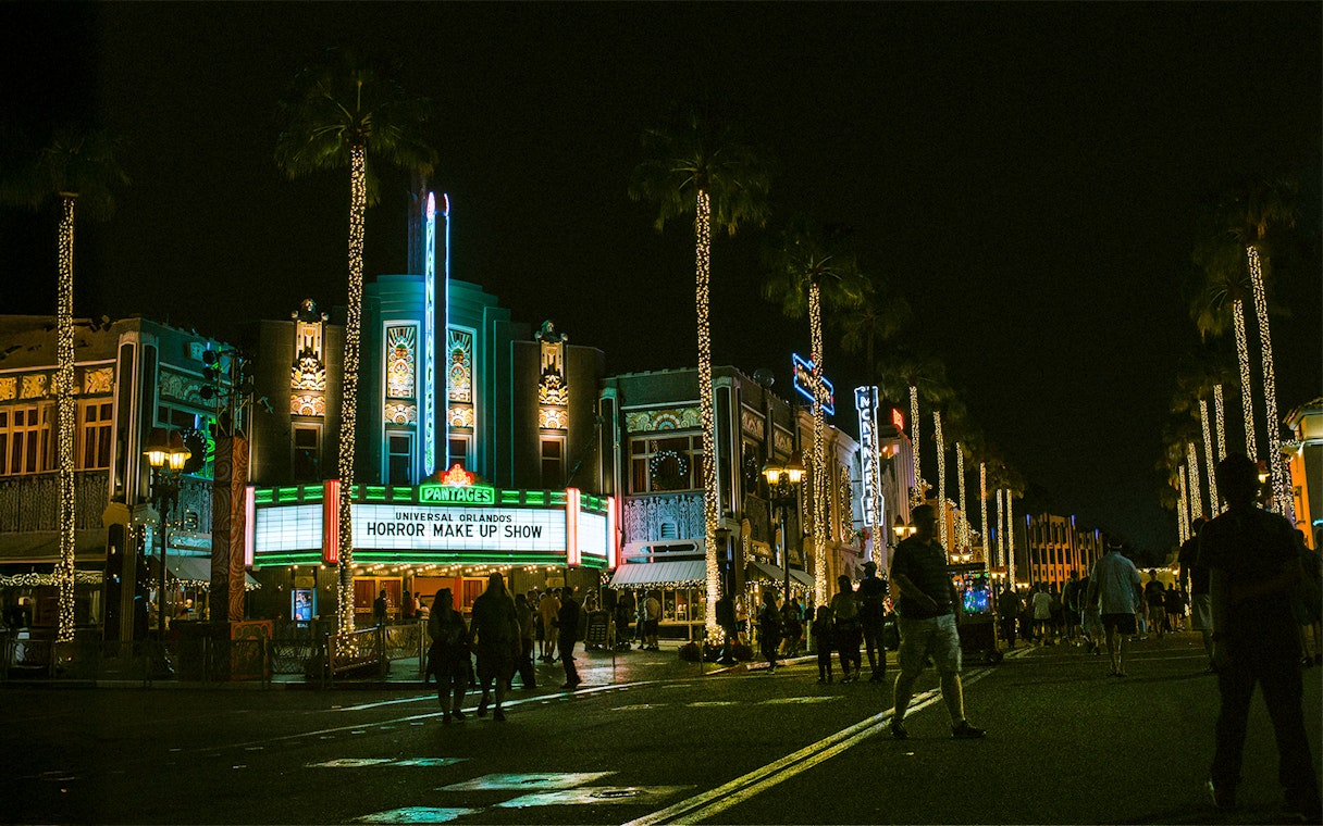 Universal Orlando's Horror Make Up Show marquee at night with illuminated street.