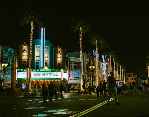 Universal Orlando's Horror Make Up Show marquee at night with illuminated street.