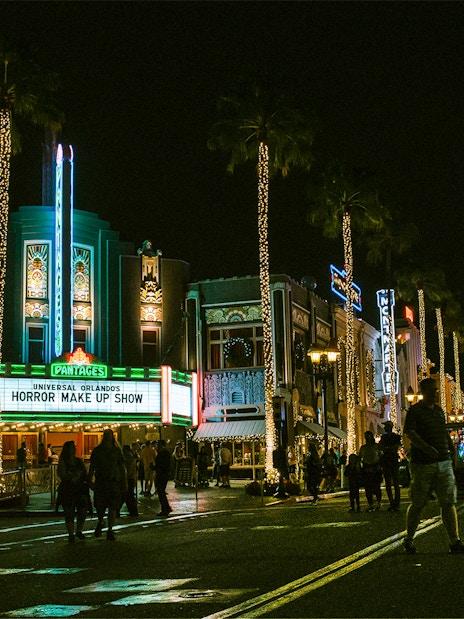 Universal Orlando's Horror Make Up Show marquee at night with illuminated street.