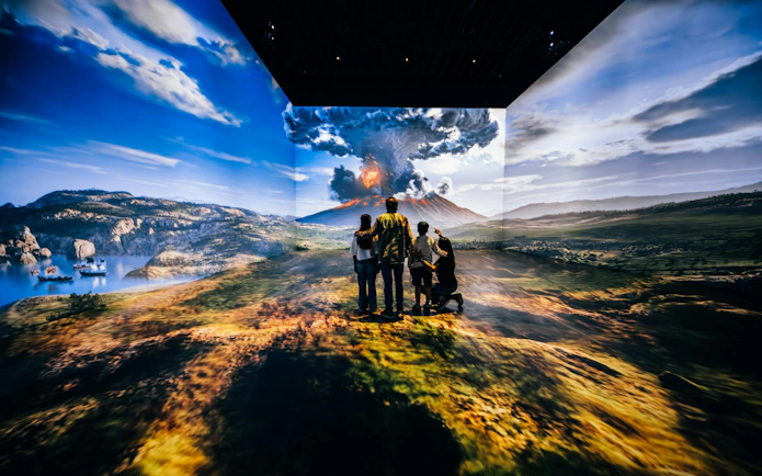 Visitors viewing immersive Pompeii eruption at IDEAL Barcelona exhibit.