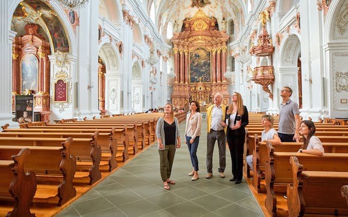 Group on guided walking tour inside ornate cathedral with official guide.