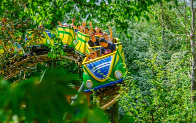 Colorful buggies on a roller coaster ride through lush greenery in Brazil.