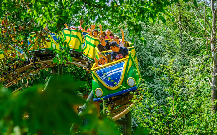Colorful buggies on a roller coaster ride through lush greenery in Brazil.
