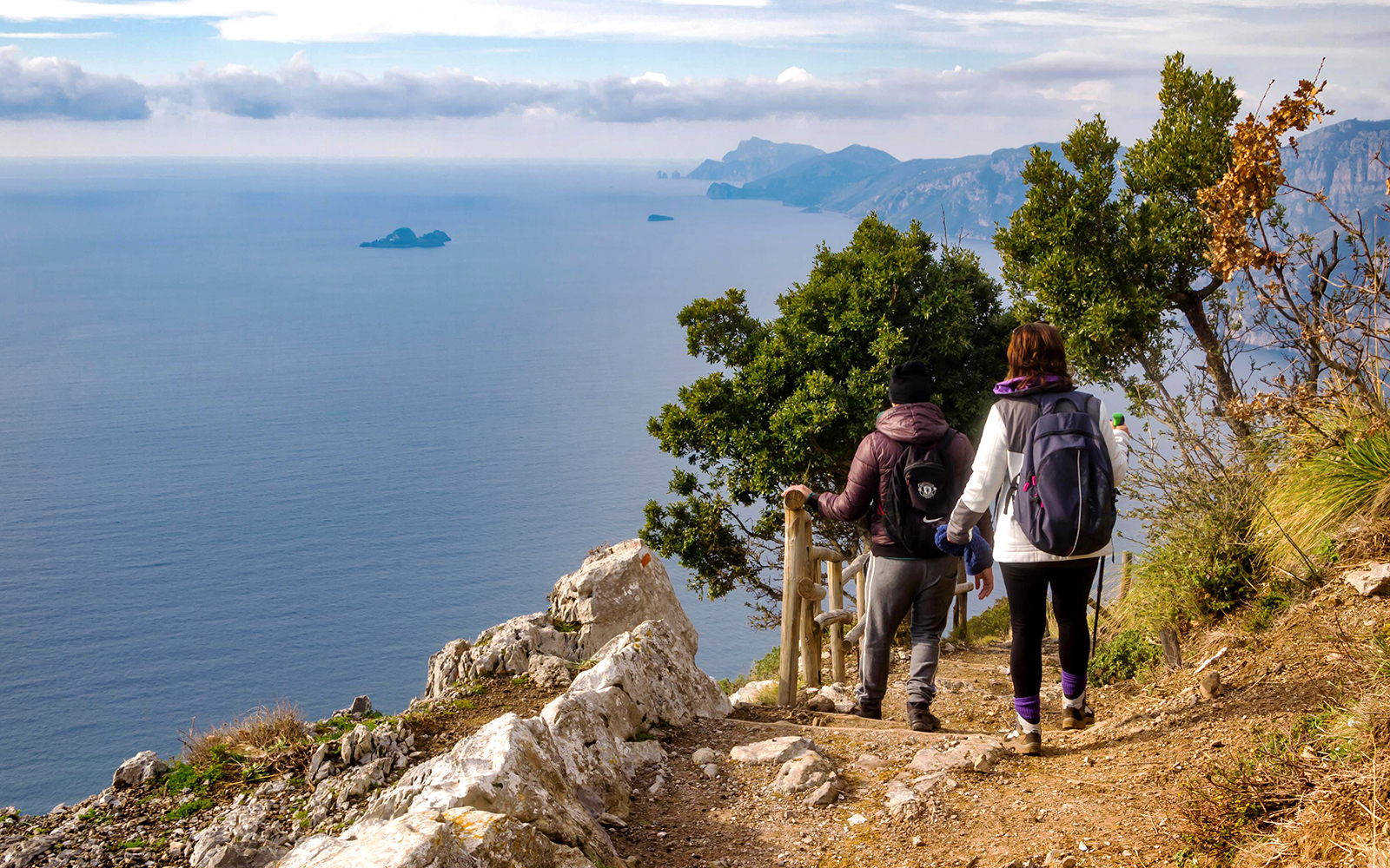 Hikers on Sentiero degli Dei trail with views of Amalfi Coast, Italy.