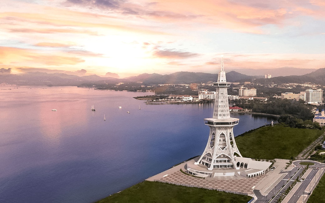 Maha Tower overlooking the waterfront in Malaysia at sunset.