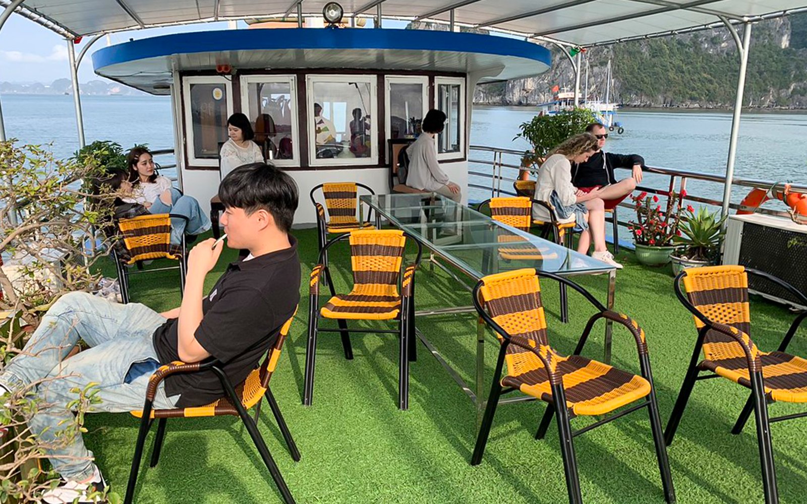 People relaxing on the Dragonfly Standard Cruise deck with scenic water views.