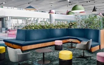 Modern lounge area with blue seating and plants at MOL Campus interior.