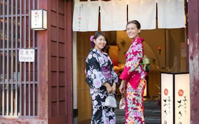 Women in traditional kimonos at a shop entrance in Shirakawa-go during a day tour from Kanazawa.