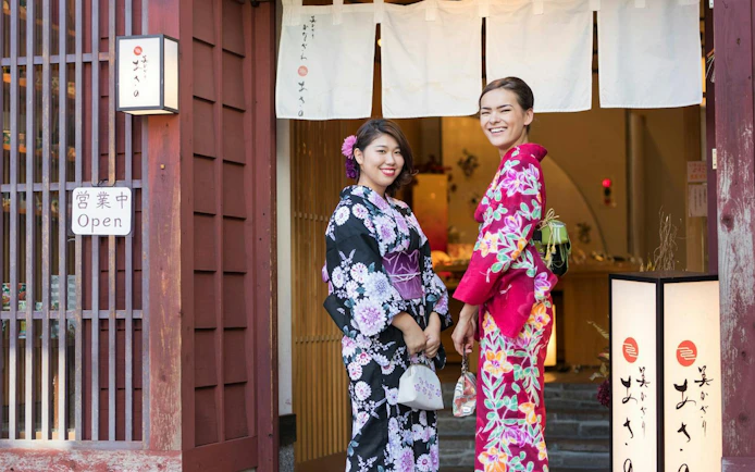 Women in traditional kimonos at a shop entrance in Shirakawa-go during a day tour from Kanazawa.