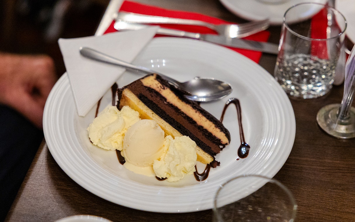 Chocolate cake with ice cream served on a plate during the Evening Rainforest & Glow Worm Experience.