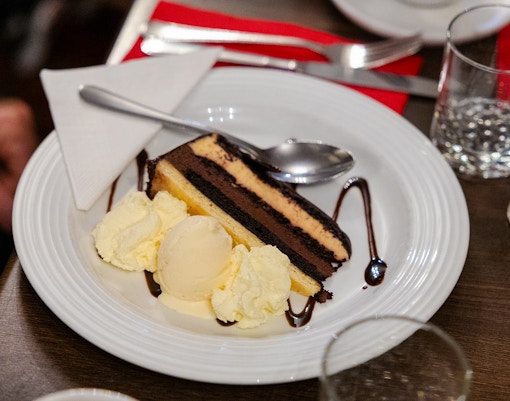 Chocolate cake with ice cream served on a plate during the Evening Rainforest & Glow Worm Experience.
