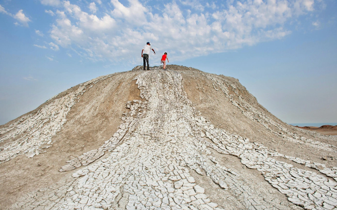 Visitors exploring mud volcano in Gobustan Reserve, Azerbaijan.