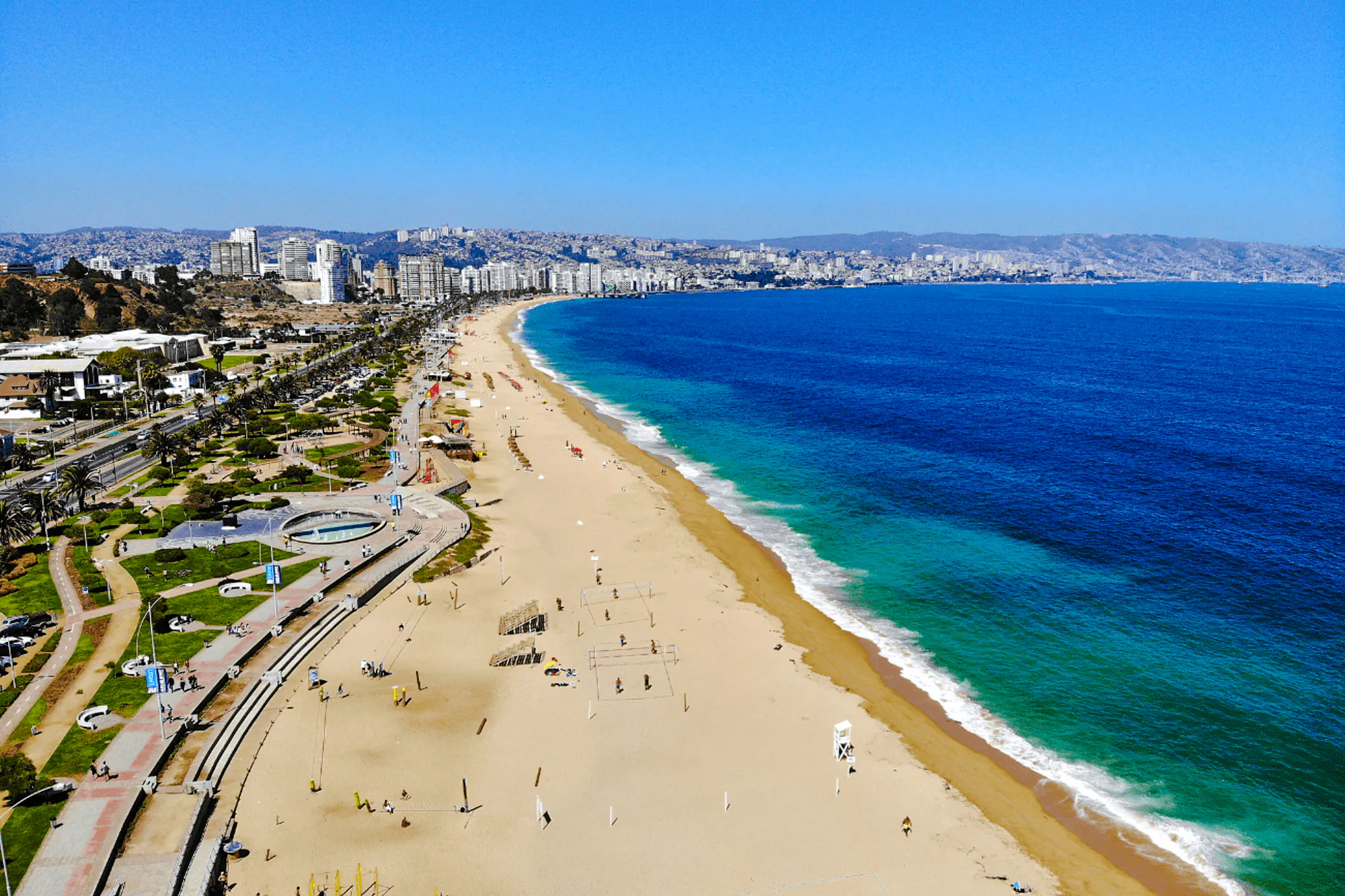 Aerial view of Reñaca Beach in Viña del Mar, Chile, with city skyline and ocean.