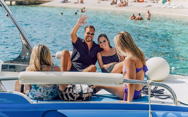 Guests relaxing on a speedboat in Blue Lagoon, enjoying the sunny day.