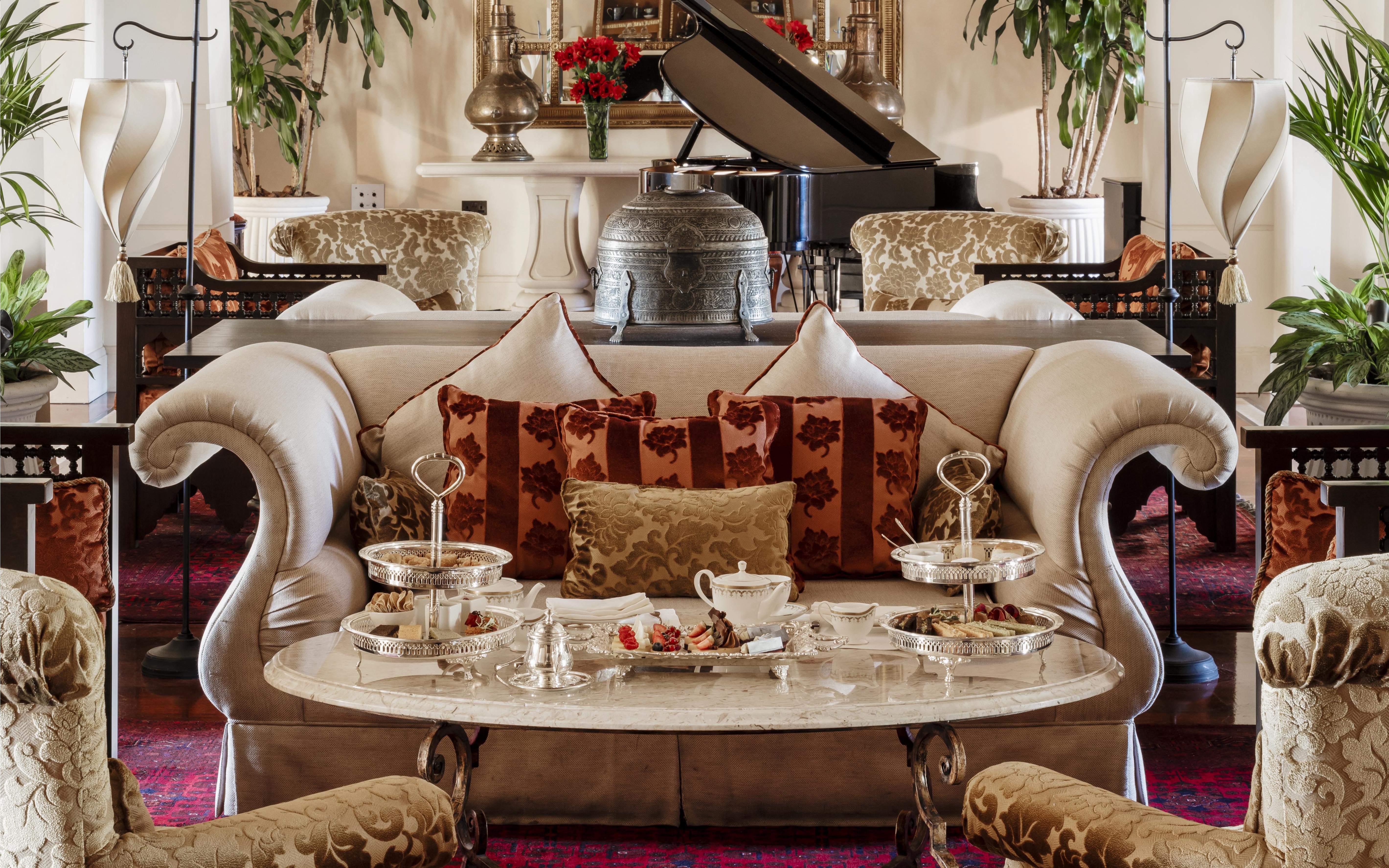 Afternoon tea setup at The Samovar Lounge, Dubai with elegant seating and silver trays.