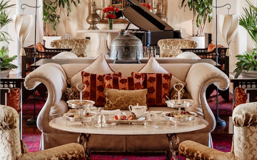 Afternoon tea setup at The Samovar Lounge, Dubai with elegant seating and silver trays.