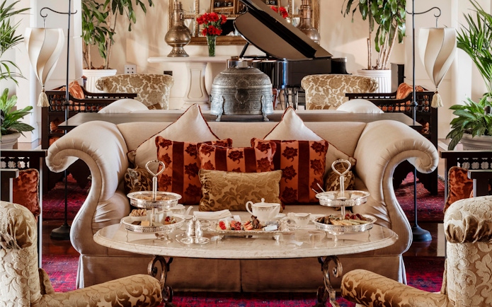 Afternoon tea setup at The Samovar Lounge, Dubai with elegant seating and silver trays.