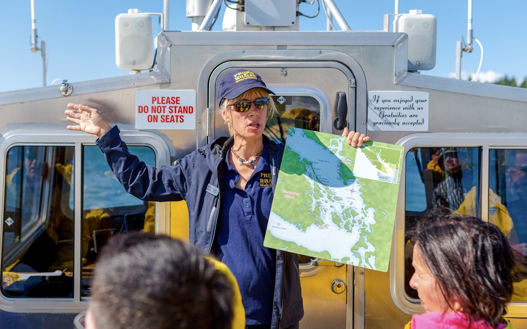 Guide explaining boat tour route with map in hand, Vancouver Island.