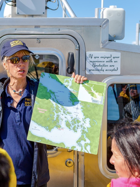 Guide explaining boat tour route with map in hand, Vancouver Island.