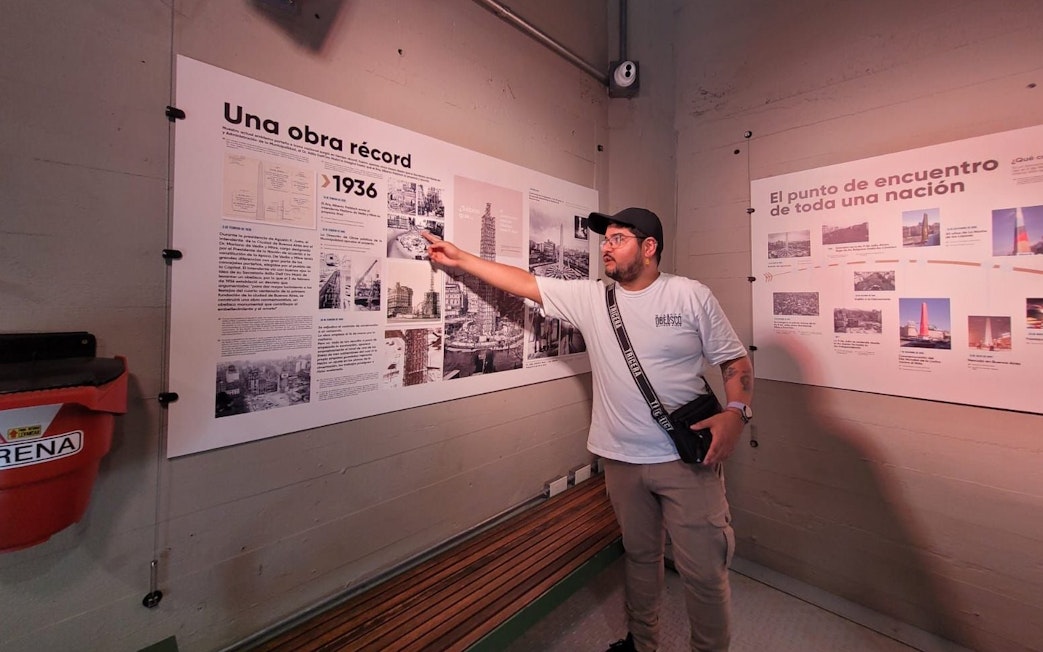 Tourist with guide explaining history at Obelisco de Buenos Aires, Argentina.