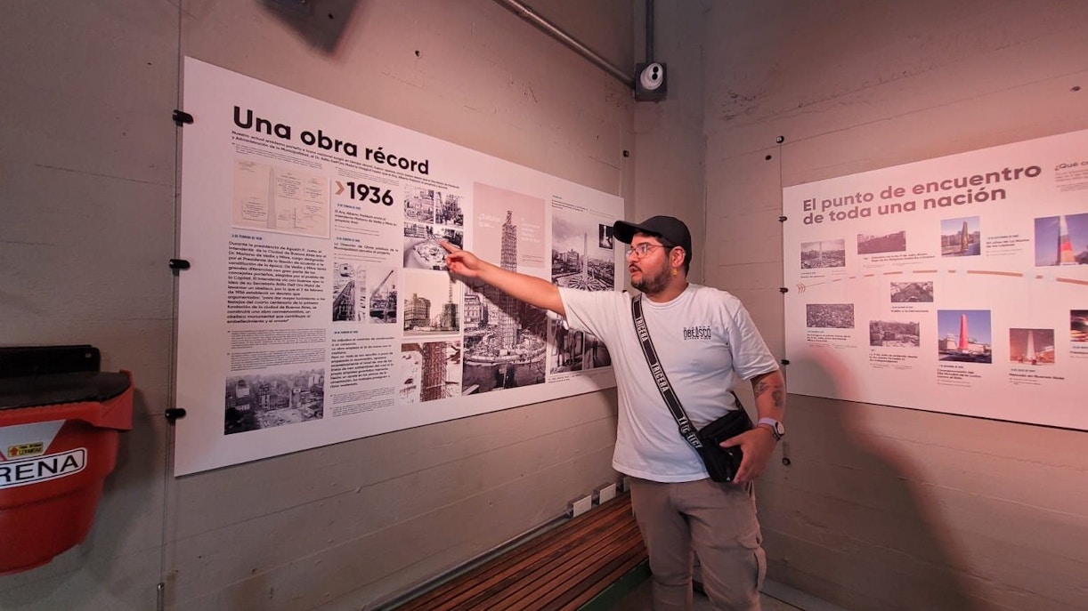 Tourist with guide explaining history at Obelisco de Buenos Aires, Argentina.