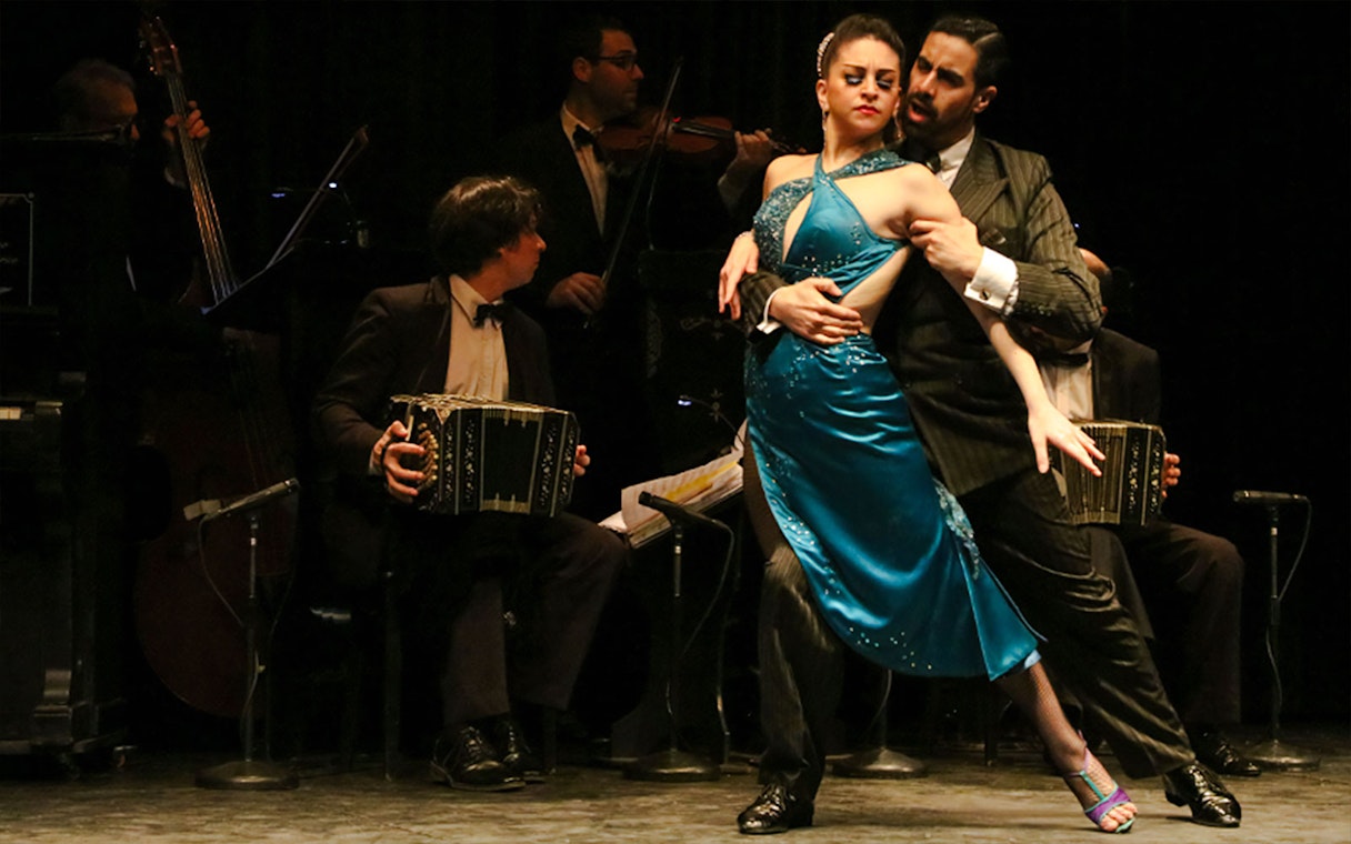 Dancers performing at La Ventana Tango Show in Buenos Aires with live musicians.
