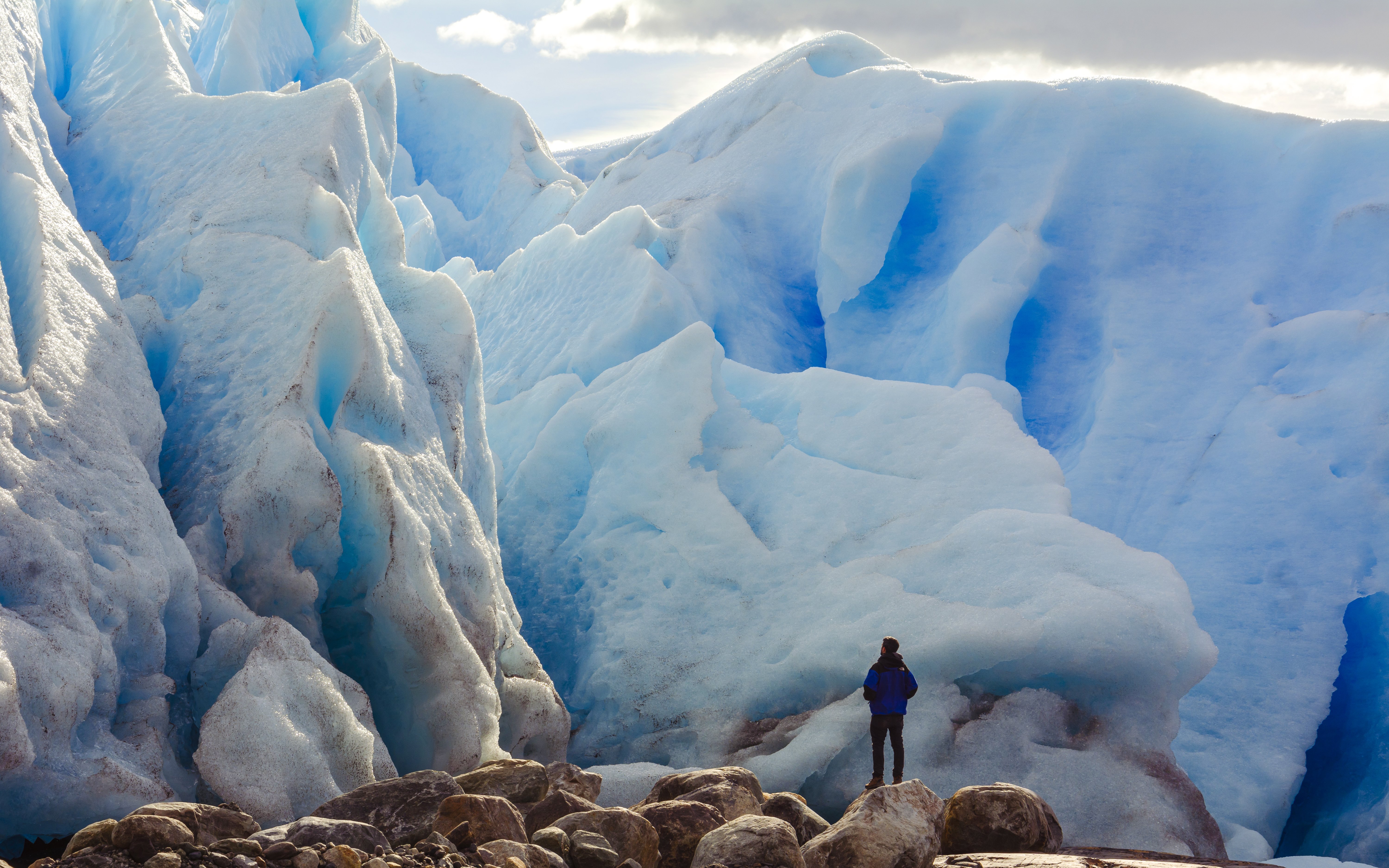Person in front of large blue glacier on Copia de Safari Azul tour.