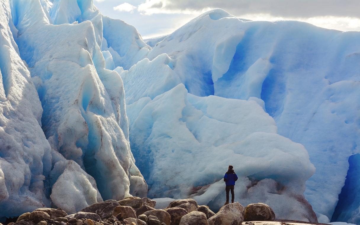 Person in front of large blue glacier on Copia de Safari Azul tour.