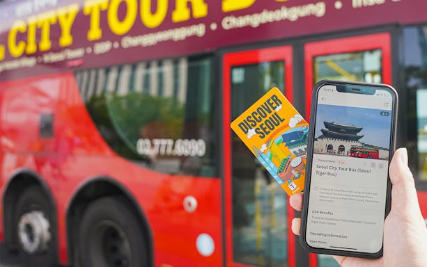 Seoul city tour bus ticket and mobile app in front of red bus.