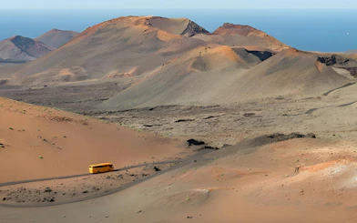 Bus on Timanfaya National Park route with volcanic landscape, Lanzarote.