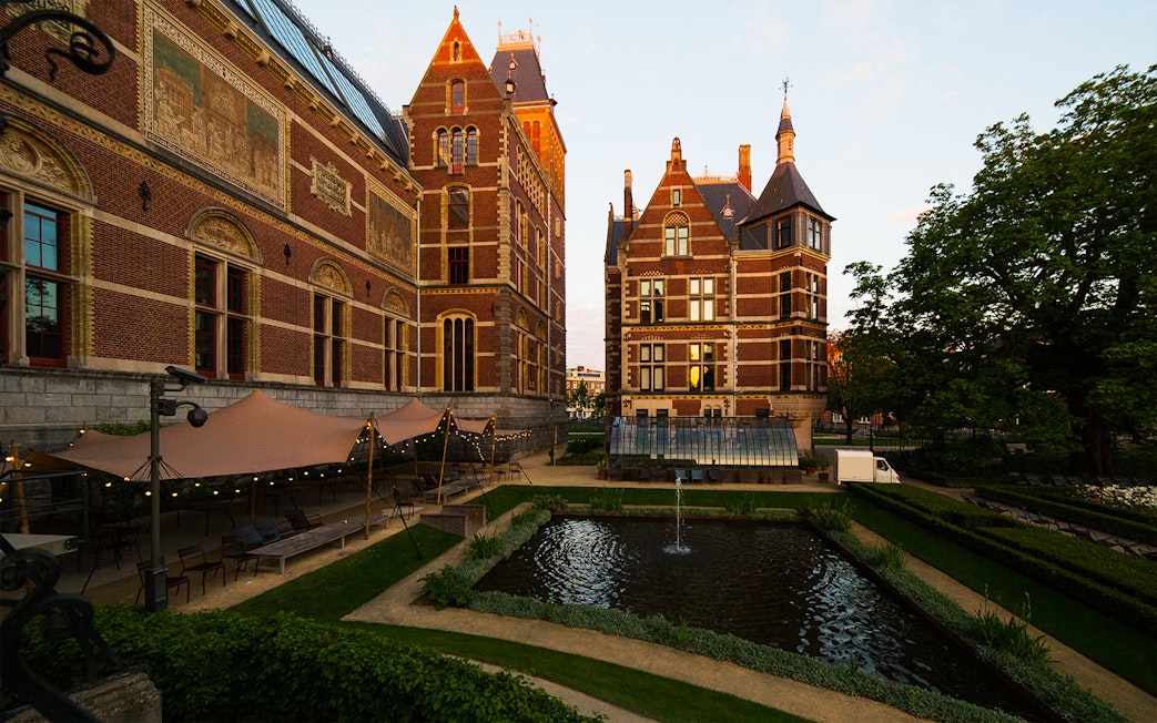 Rijksmuseum garden with pond and historic brick architecture in Amsterdam.