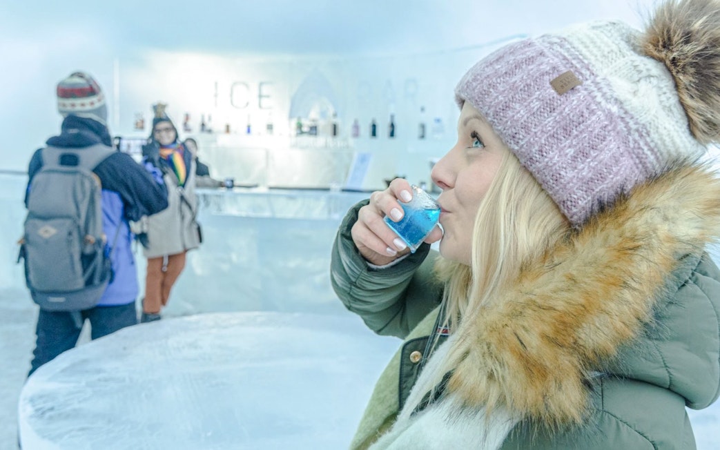 Guests enjoying drinks at the ice bar inside Arctic SnowHotel.