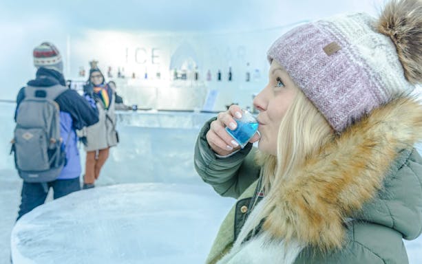 Guests enjoying drinks at the ice bar inside Arctic SnowHotel.