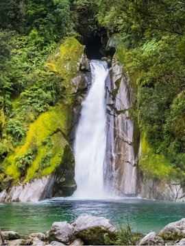 Waterfall cascading over rocks surrounded by lush greenery at Giant Gate Falls.