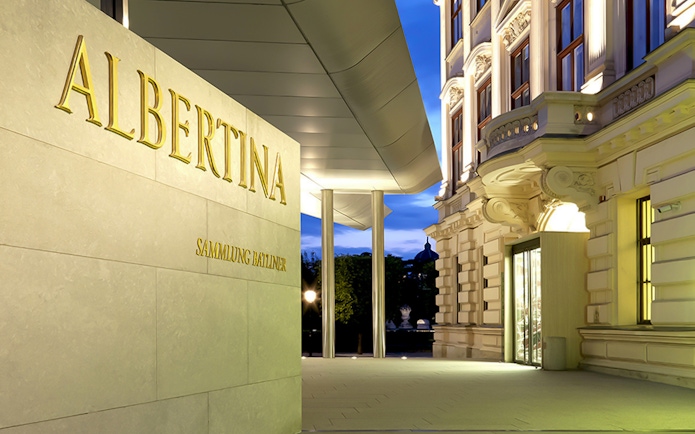 Albertina Museum entrance with illuminated facade in Vienna.