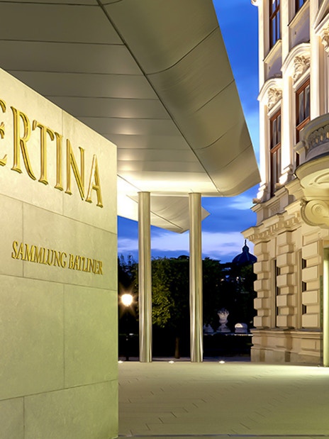 Albertina Museum entrance with illuminated facade in Vienna.