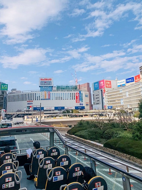 Tourists on Sky Hop Bus in Tokyo viewing cityscape and landmarks.