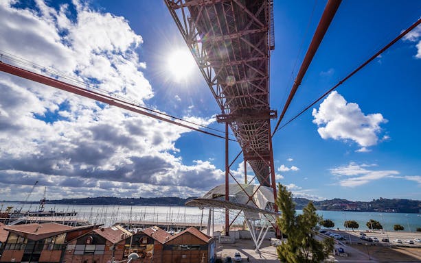 Pilar 7 Bridge Experience view from below with river and marina in Lisbon.
