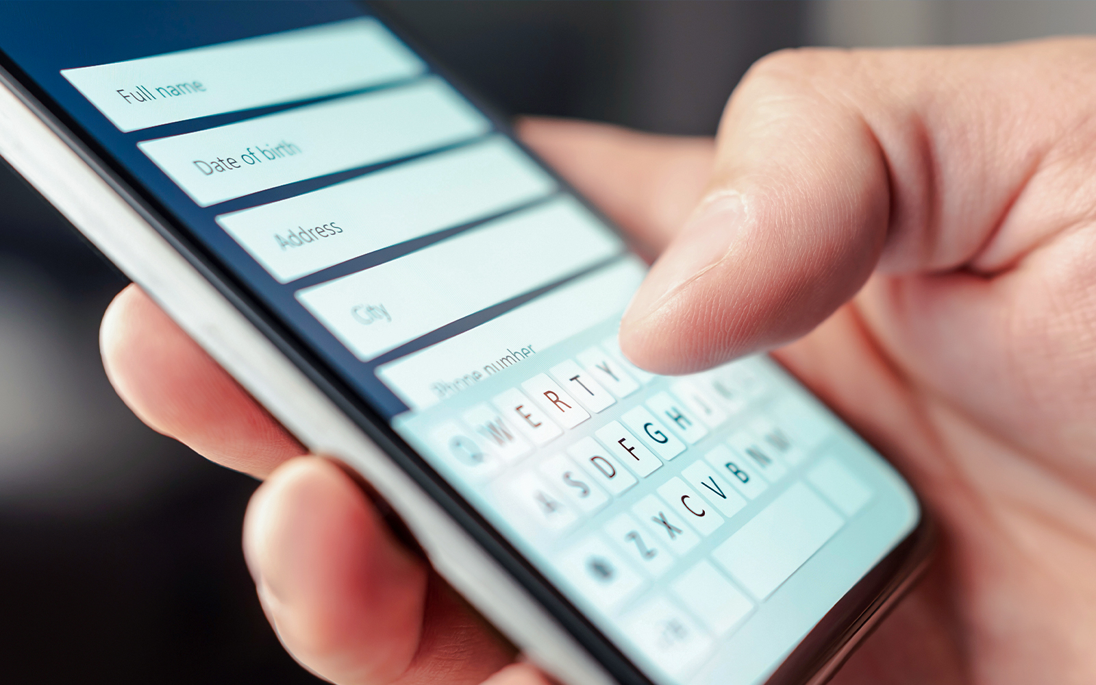 Person entering information on a smartphone form.