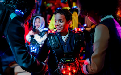 Children playing laser tag in Rotterdam with glowing vests and equipment.